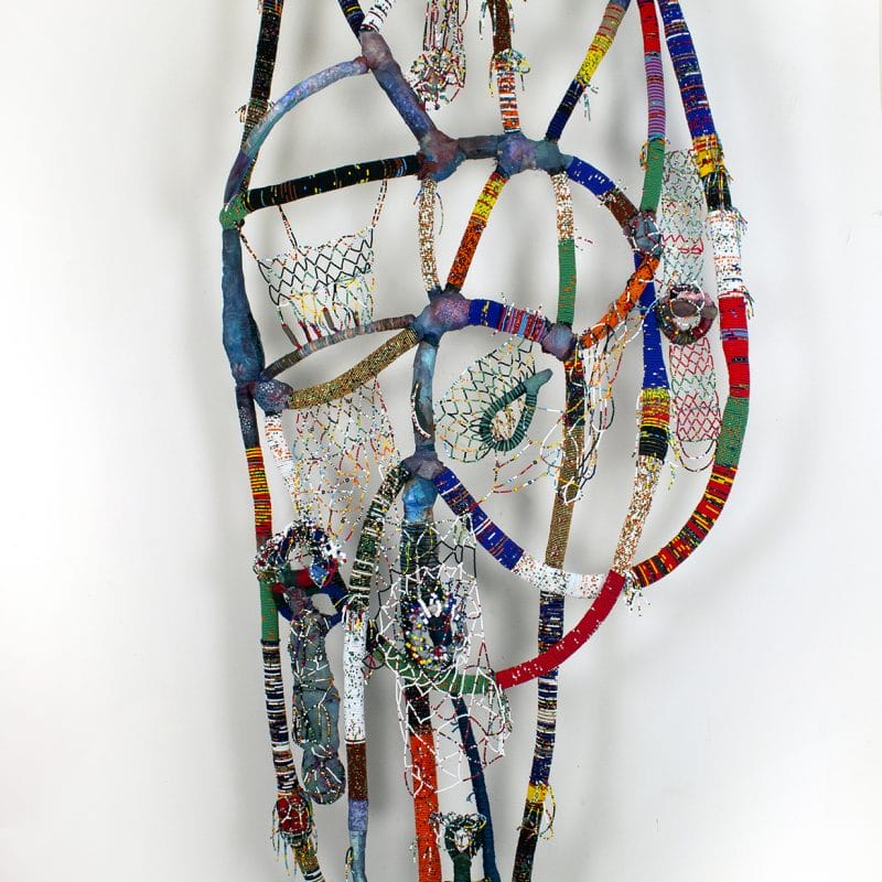 Black Joy Takes Courage, 2019, caucasian doll, fabric/clothes, acrylic, gel-medium, monofilament, leather, glass seed beads, hand-made ceramic bead, plastic pony hair beads, and miscellaneous.  Dimensions: 98" X 48" X 5".  Courtesy Claire Oliver Gallery