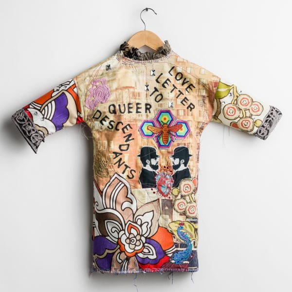 "Love Letter to Queer Descendants" by MIchael Sylvan Robinson was shown at the Wisconsin Museum of Quilts and Fiber Arts (2021) and at the Textile Center of Minneapolis (2020). Sculptural garment with textile collage, stenciled text and wood block printing with machine and hand-stitching, sequins and beading, buttons on fabric (2021) h: 28" x w: 32" x 2" Photo credit: Paul Takeuchi