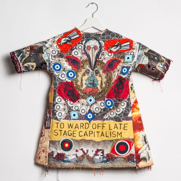 "to ward off late stage capitalism" by MIchael Sylvan Robinson was shown at SPRING / BREAK Art Show in NYC, Sept 2021 in exhibition curated by Katrina Majkut. Sculptural garment with textile collage, stenciled text and wood block printing with machine and hand-stitching, sequins and beading, buttons on fabric (2021) h: 28" x w: 32" x 2" Photo credit: Paul Takeuchi
